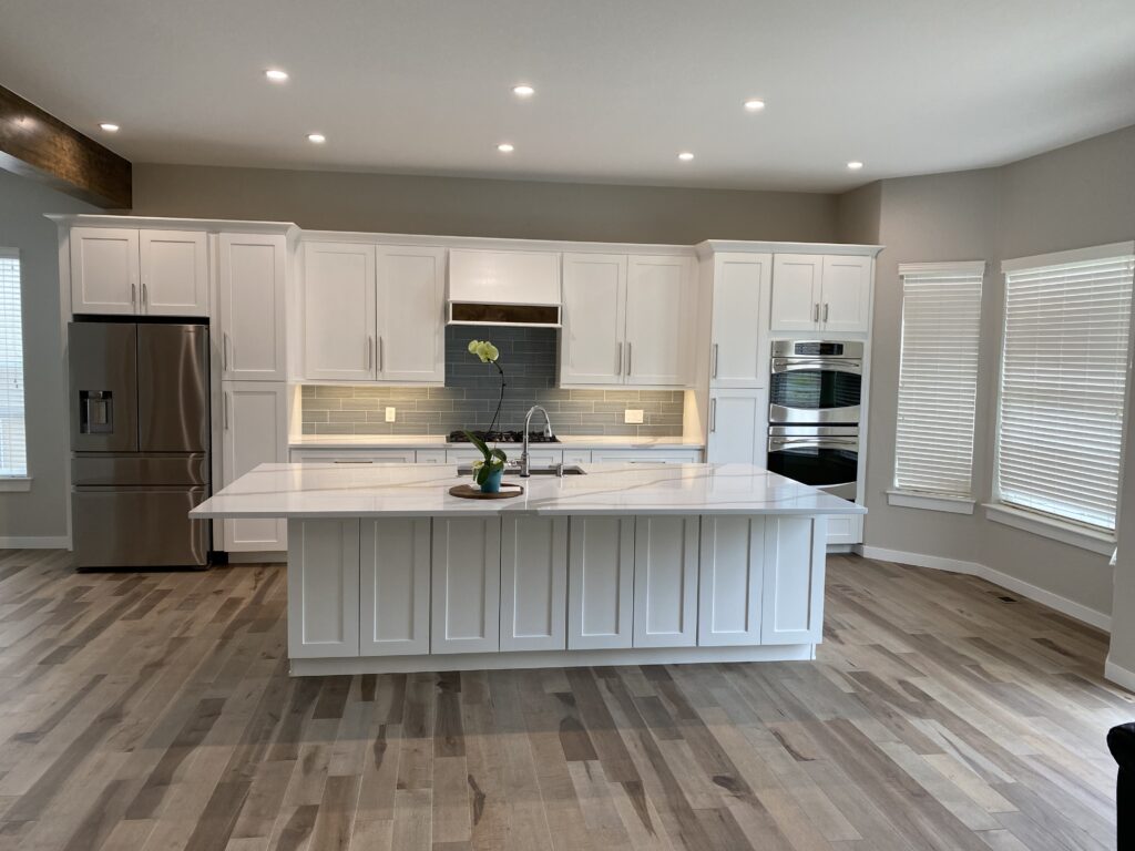 Spacious kitchen with large white island and stainless steel appliances